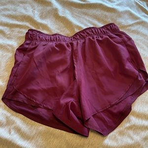 Athletic, plum colored running shorts.